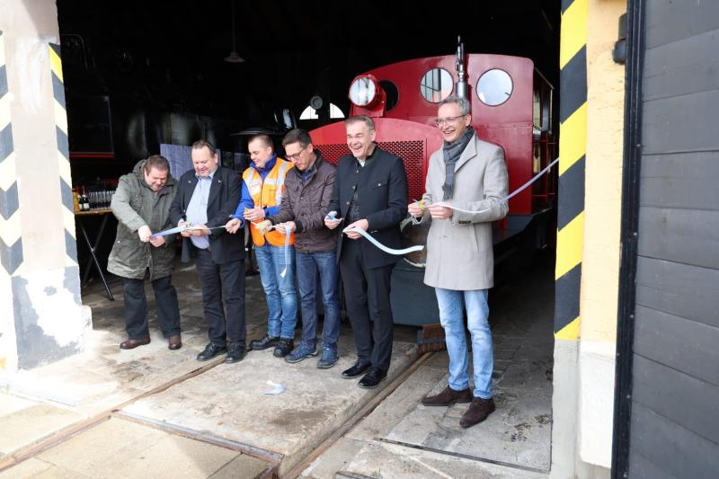Eisenbahnbetriebsleiter Matthias Büttner von der Museumsbahn Schönheide, der 1. Vorsitzende des Modell- und Eisenbahnclubs Selb-Rehau e.V Michael Pelz, der 2. Vorsitzender des Modell- und Eisenbahnclubs Selb-Rehau e.V Gregor Denndörfer, der Rehauer Bürgermeister Michael Abraham, Landrat Peter Berek und der Selber Oberbürgermeister Ulrich Pötzsch (von links nach rechts) durchschneiden das Band, um für die dahinter stehende Lok Kirchenlamitz die erste öffentliche Fahrt freizugeben.